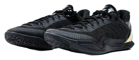 Black low-cut lace-up basketball shoe with textured knit upper and detailed outsole