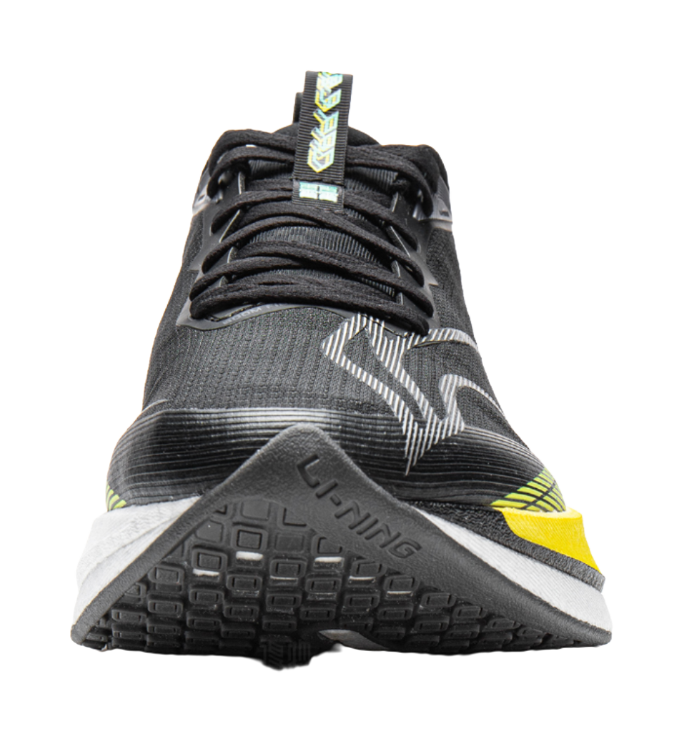 Unisex running shoe close-up, black mesh upper with yellow heel stripe and lace detail