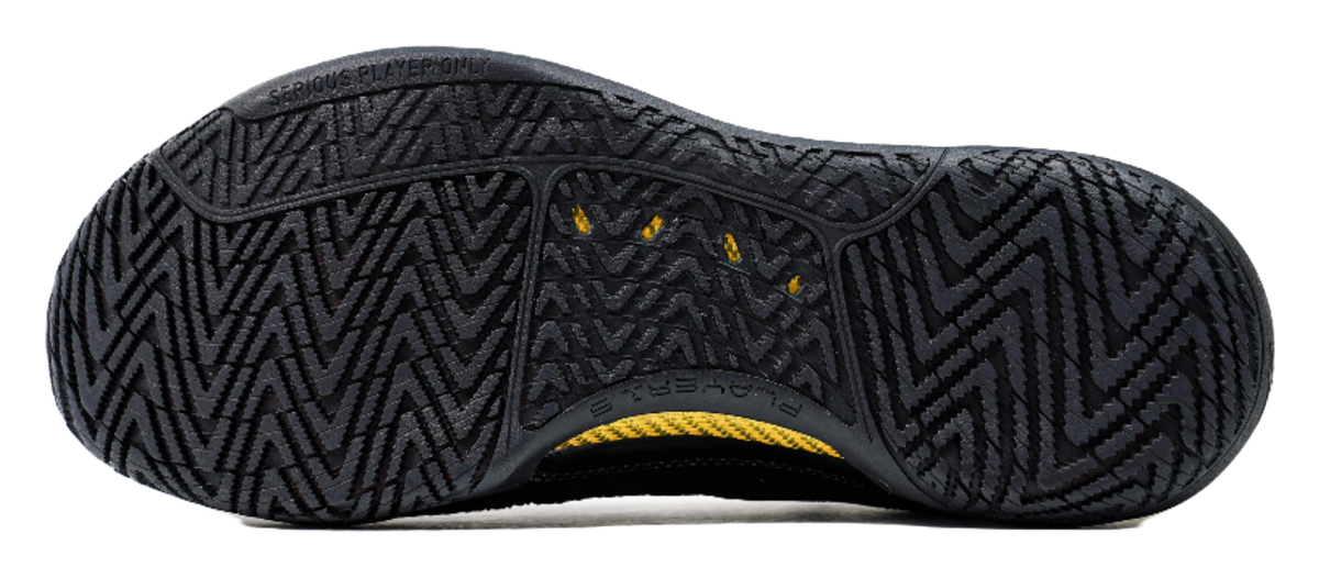 Black basketball shoe outsole with zigzag traction tread and yellow midsole stripe