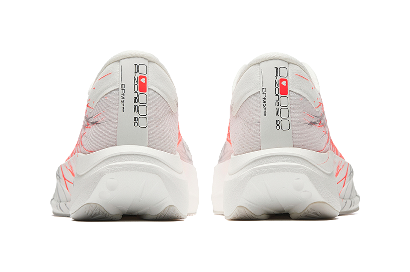 White running shoes with red accents on the heel, cushioned light gray sole