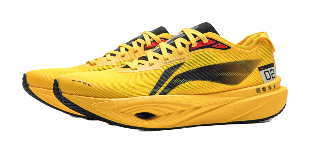 Yellow low-top running shoe, front side view, black stripe and red logo detail.
