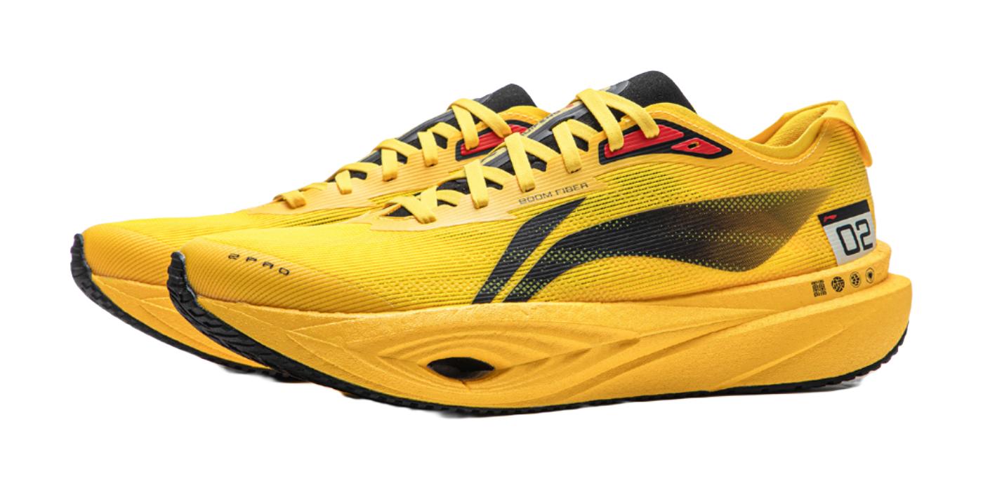 Yellow low-top running shoe, front side view, black stripe and red logo detail.