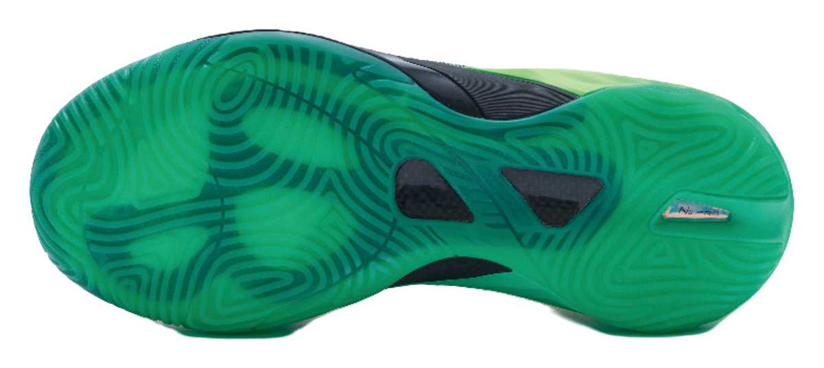 Green basketball shoe outsole with textured traction pattern and dark grip pods