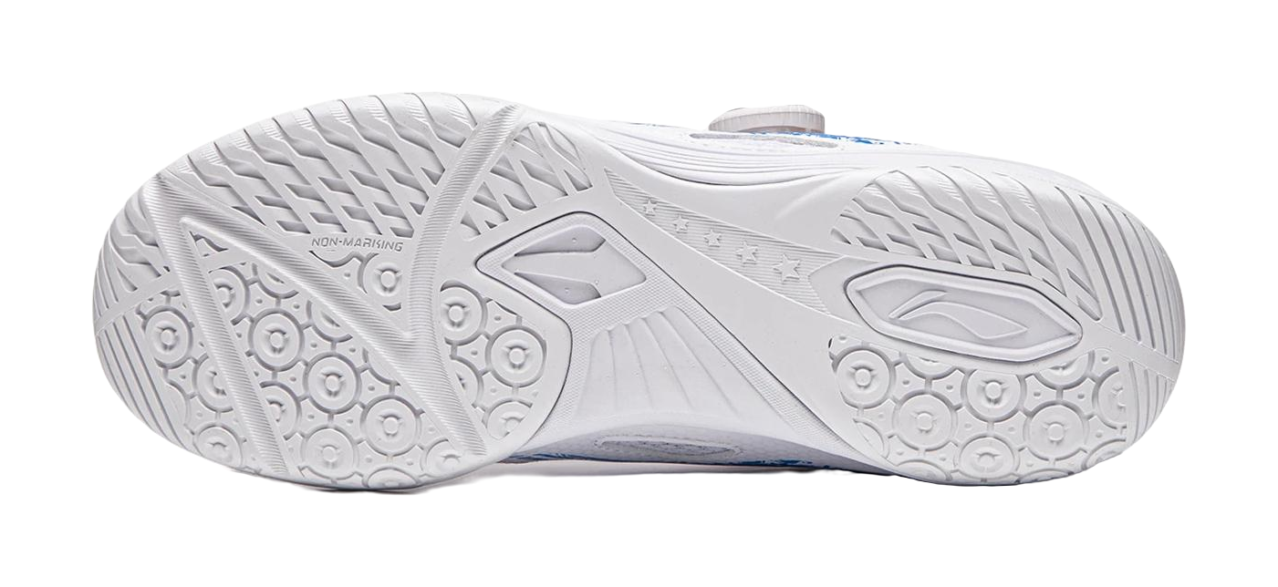 White table tennis shoe outsole with circular grip nodes and angular tread patterns.