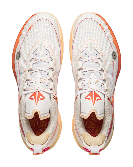 Pair of white basketball shoes with orange laces, magenta tongue detail