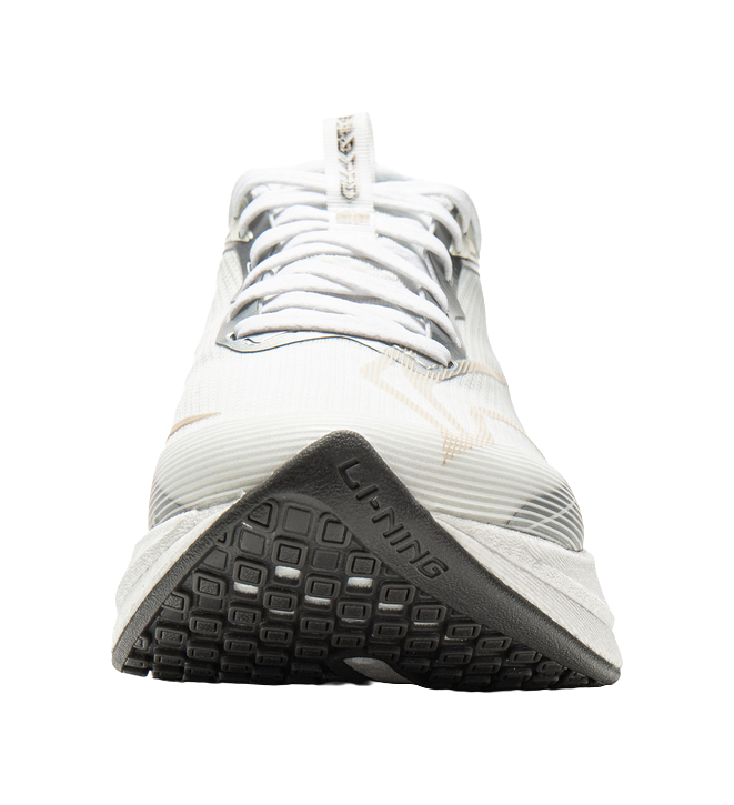 White running shoe outsole with black tread and textured grip, underside view.