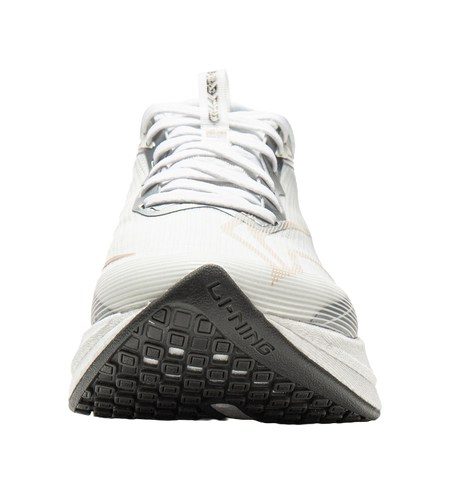 White running shoe outsole with black tread and textured grip, underside view.