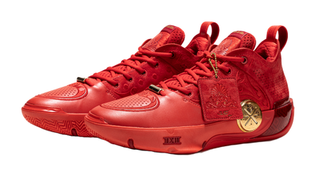 Red mid-top basketball shoes with lace-up front and gold emblem on the side.
