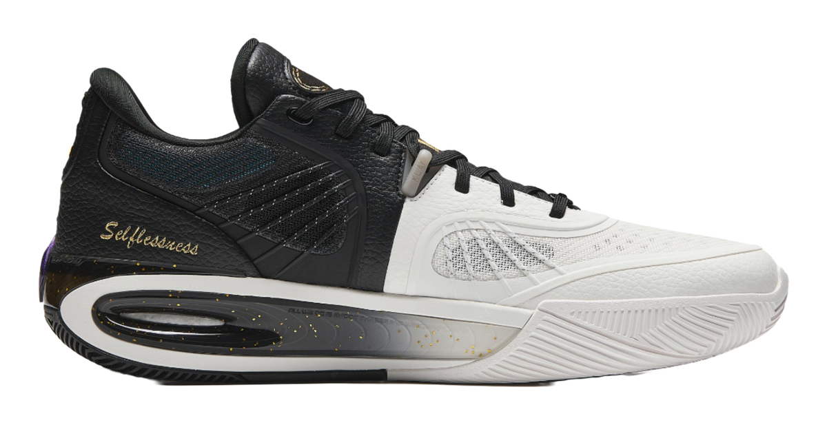 Low-top lace-up basketball shoe in black and white with gold speckled details