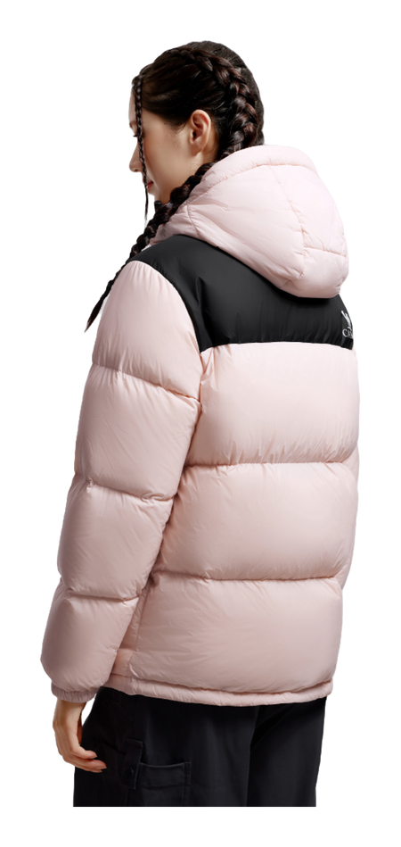 Model wearing unisex pink hooded puffer down jacket in side view with black chest panel