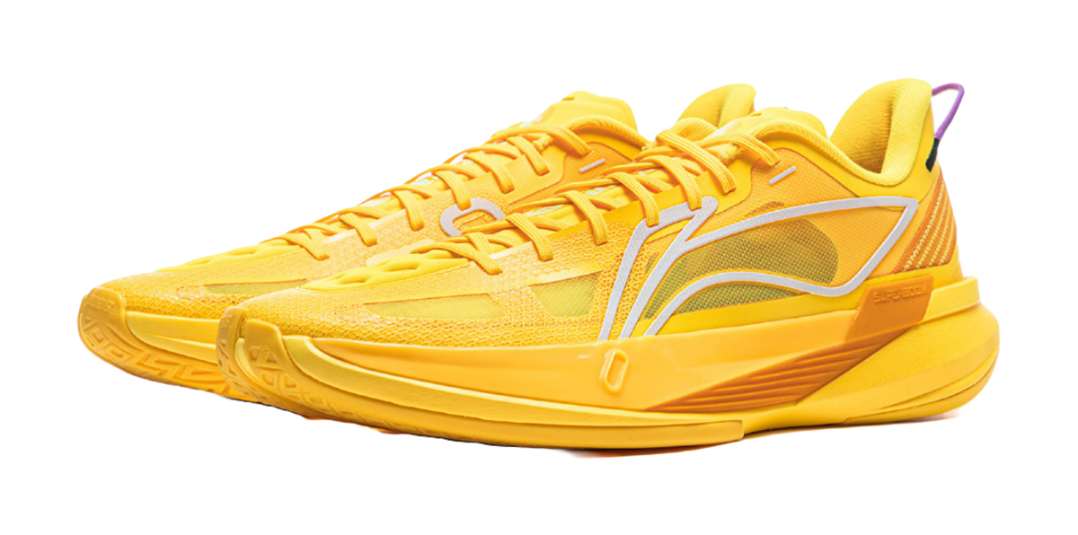 Yellow basketball shoe with white curved side stripe and cushioned sole