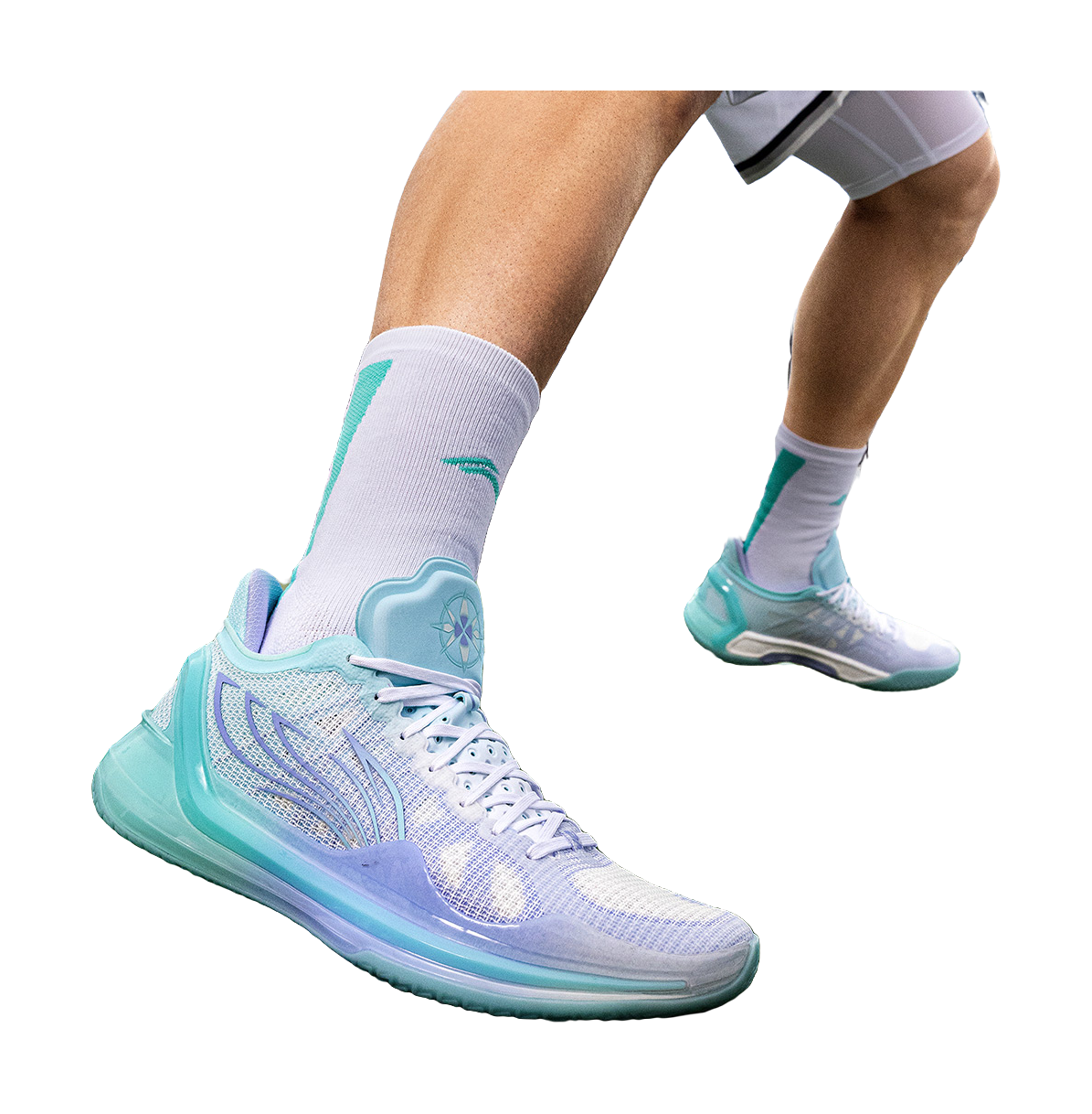 Low-top basketball shoes on feet in light blue and teal with white laces and cushioned sole
