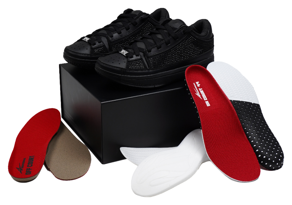 Black basketball shoes with red insole inserts and lace-up uppers, laid out.