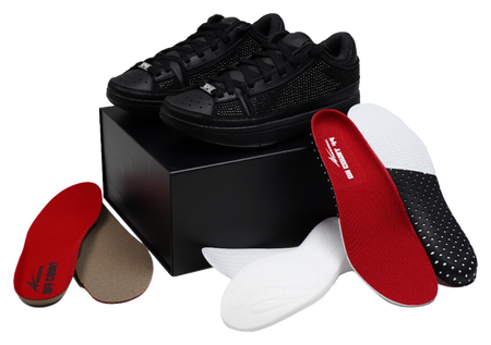 Black basketball shoes with red insole inserts and lace-up uppers, laid out.