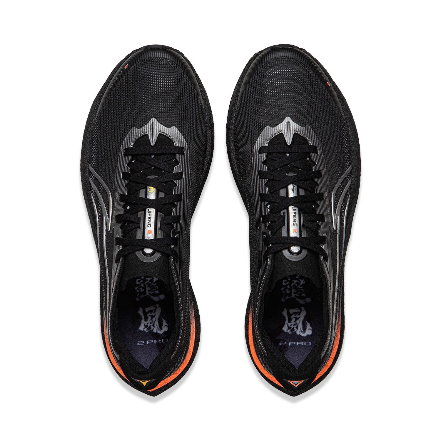 Pair of black running shoes, top view with laces, silver stripes, orange-lined collar