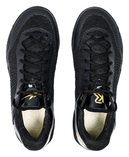 Pair of black lace-up basketball shoes showing front toe and laces with yellow accents