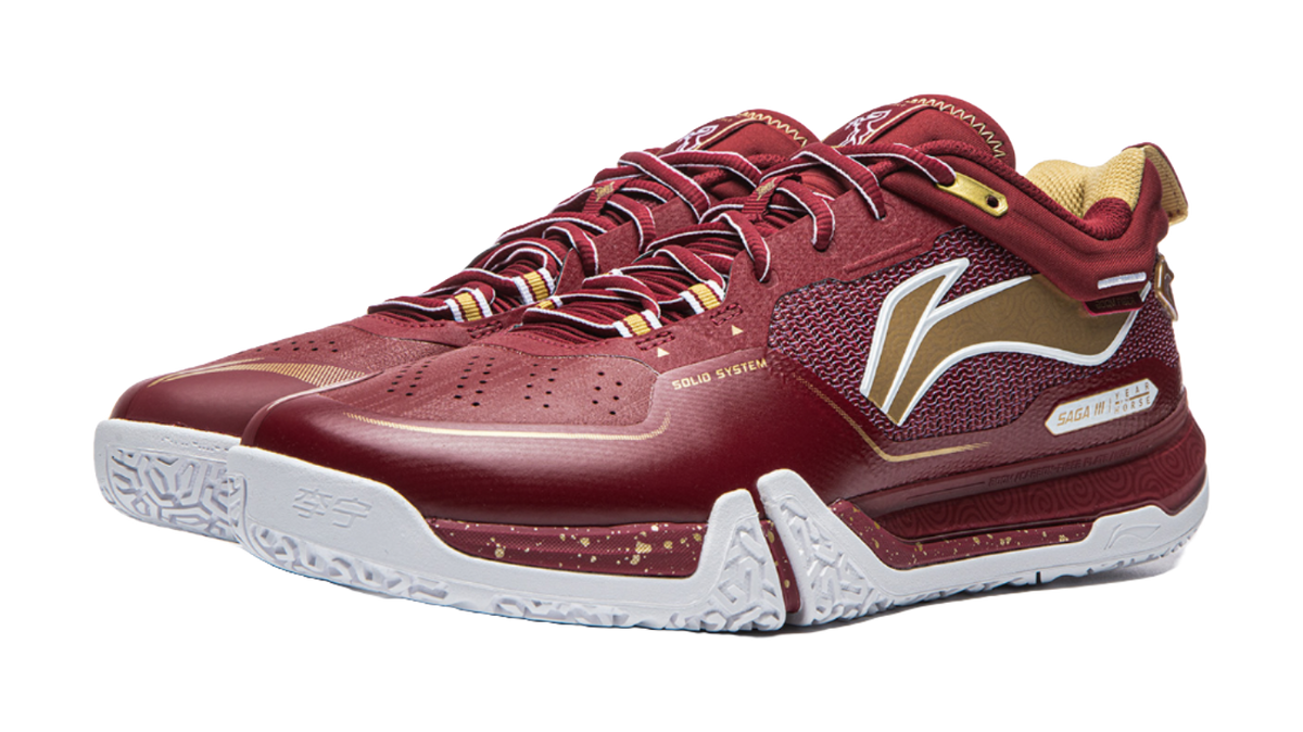 Red badminton shoe angled view with white midsole, side graphic, and lace-up upper.