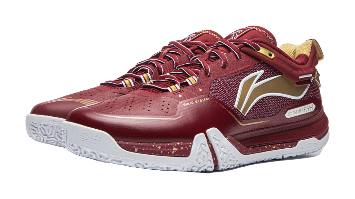 Red badminton shoe angled view with white midsole, side graphic, and lace-up upper.