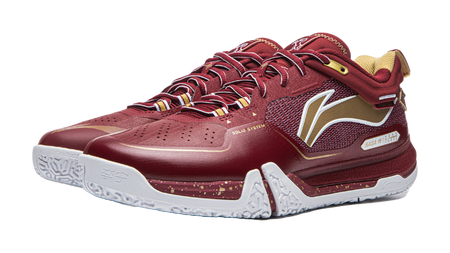 Red badminton shoe angled view with white midsole, side graphic, and lace-up upper.