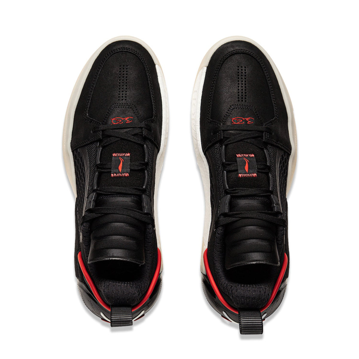 Pair of black basketball shoes with red trim and white soles, lace-up.