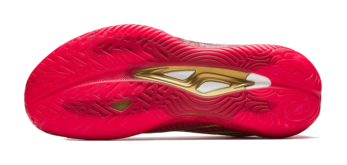 Red shoe outsole with textured traction pattern and gold branding on heel.