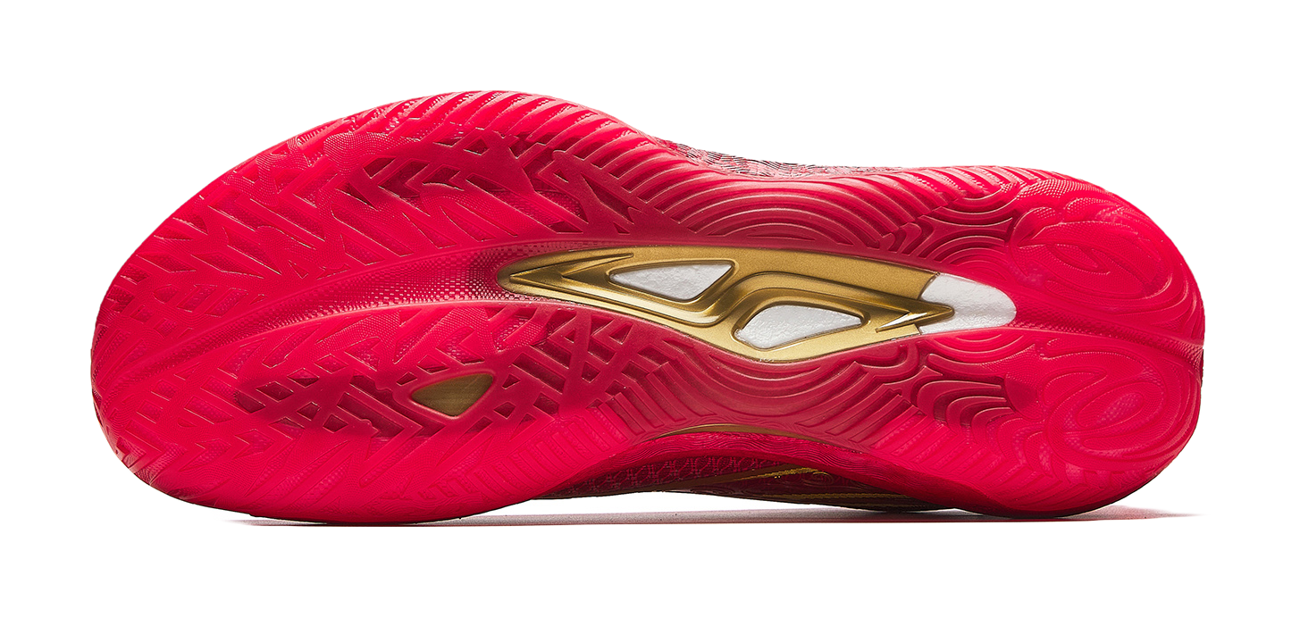 Red shoe outsole with textured traction pattern and gold branding on heel.