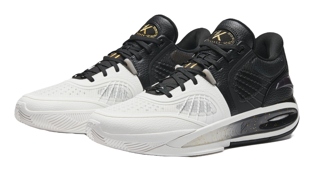 Pair of black and white basketball shoes with padded collars and lace-up fronts