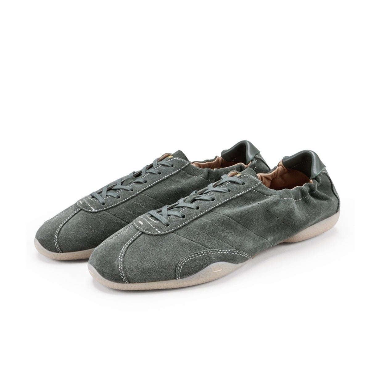 A pair of low-top suede sneakers in a muted gray-green color with white soles, shown on a plain white background.