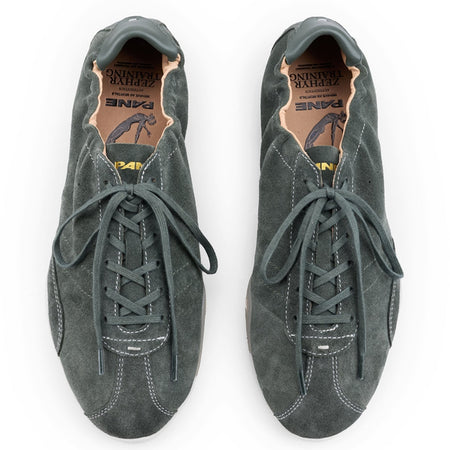 A pair of dark gray suede sneakers with laces, shown from a top-down view on a white background. The shoes have a low-top silhouette with a textured suede finish and a tan interior lining.