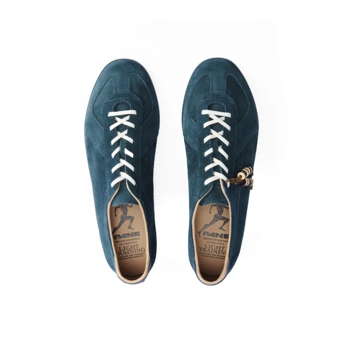 A pair of dark teal-blue suede lace-up sneakers shown from a top-down view on a white background, with white laces and a small gold-tone charm on the side.