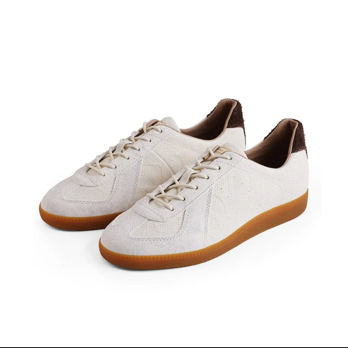 A pair of low-top sneakers in off-white leather with brown laces, brown lining, and brown gum soles, shown on a white background. The image is a screenshot from a shopping app with black bars at the top and bottom and text reading 'PYTHON ALBINO 5247'.