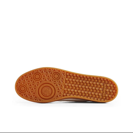 A close-up of a shoe's outsole showing a textured brown rubber tread pattern, displayed on a white background with black letterboxing and Chinese text below.