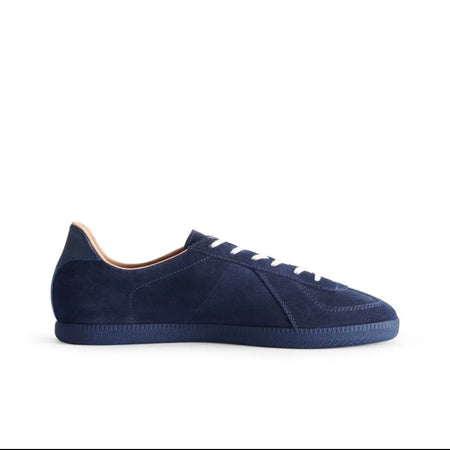 A navy blue suede sneaker shown in side profile on a plain white background, with text below reading 'DUSK INDIGO 5366'.