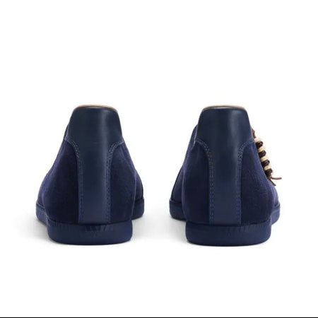 A pair of navy blue suede high-top sneakers shown from the back, displayed on a white background within a mobile app screenshot.