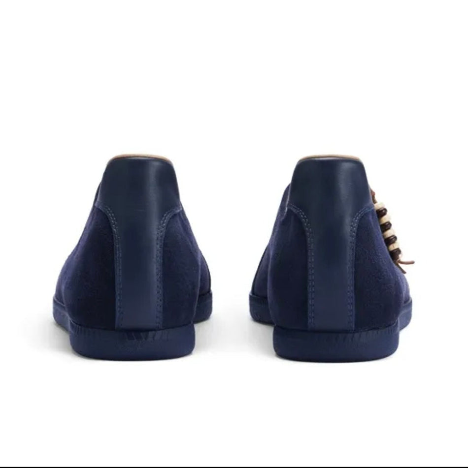 A pair of navy blue suede high-top sneakers shown from the back, displayed on a white background within a mobile app screenshot.