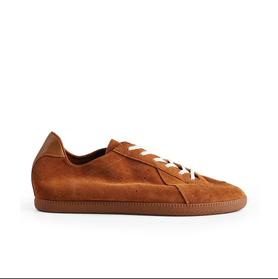 A single low-top suede sneaker in a warm ginger-brown shade, shown in side profile against a white background. The shoe has white laces and a matching brown sole, with the text 'Ground Ginger 5270' displayed below on a black mobile app interface.