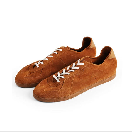 A pair of low-top suede sneakers in a warm ginger-brown color with white laces, shown on a plain white background. The image is a screenshot from a shopping app with black bars at the top and bottom and text reading 'Ground Ginger 5270' below the shoes.