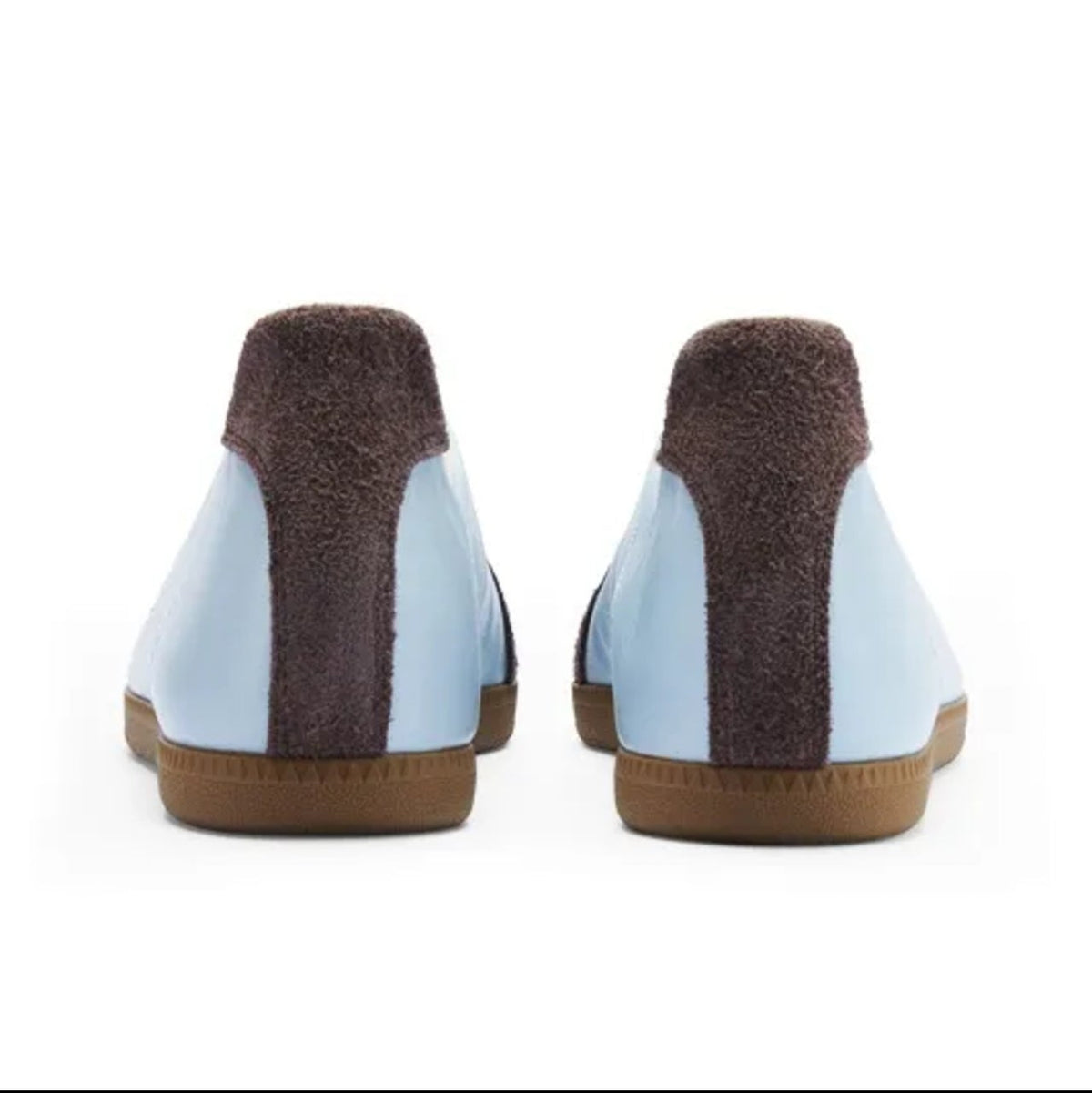 A pair of light blue and dark brown slip-on shoes shown from the back on a white background, with a black mobile app interface framing the photo.