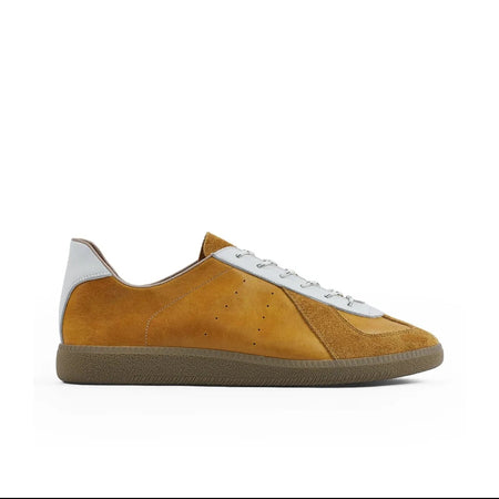 A low-top sneaker shown on a white background within a mobile app screenshot. The shoe has a mustard yellow suede upper, white laces, a white heel tab, and a brown gum sole.