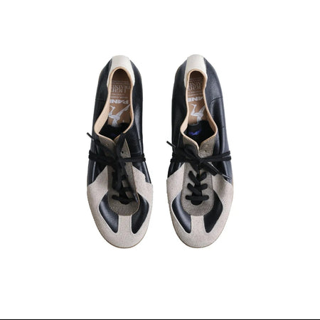 A pair of Gucci low-top sneakers in navy blue and beige leather with black laces, shown from a top-down view on a white background.