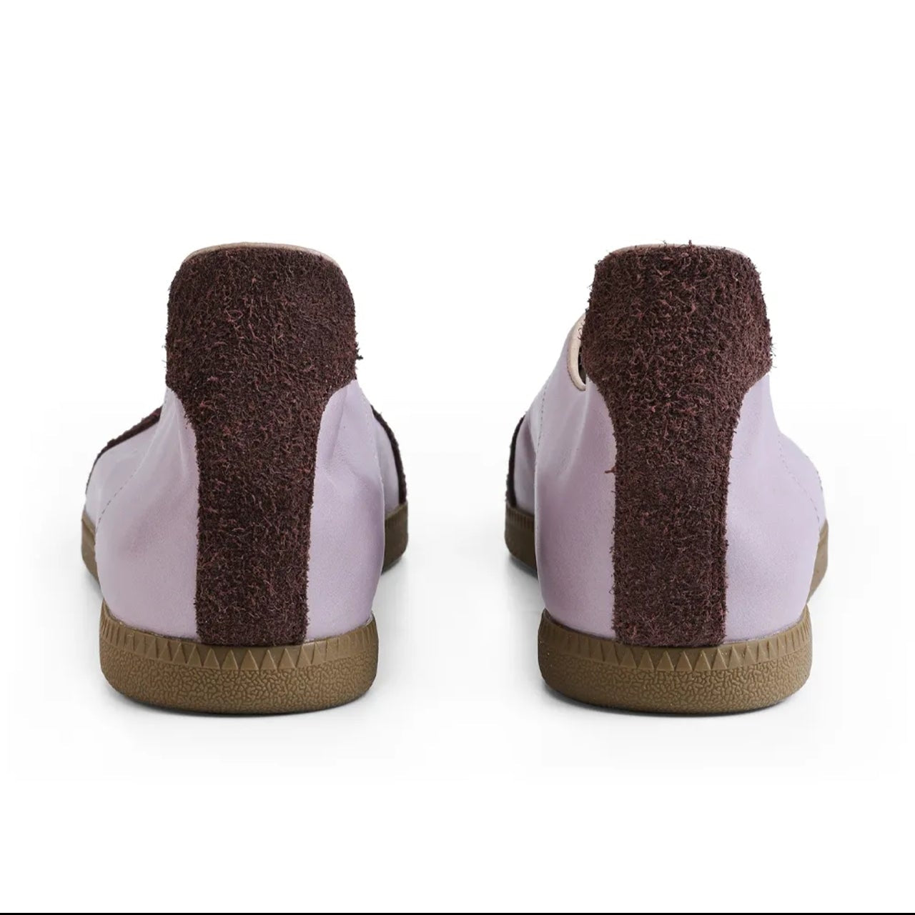 A pair of low-top slip-on shoes shown from the back on a white background, with a light lavender-purple upper, a dark brown fuzzy vertical stripe, and a tan sole.