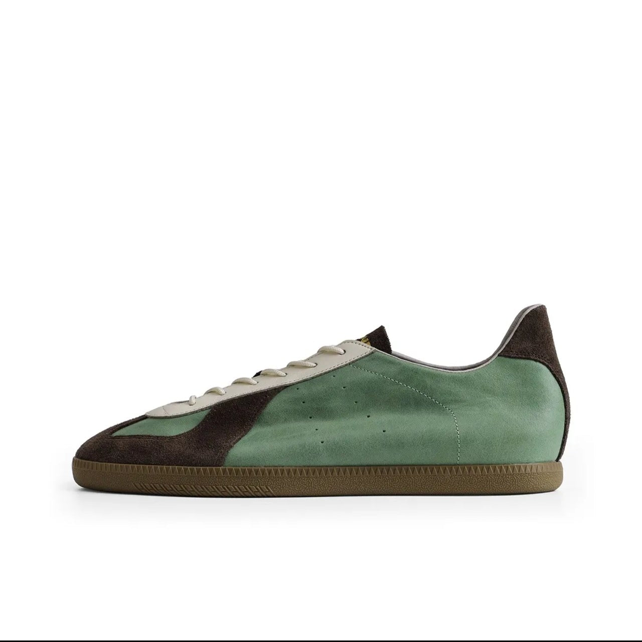 A mint green suede sneaker with dark brown suede panels on the toe and heel, featuring a gum sole, shown against a plain white background.
