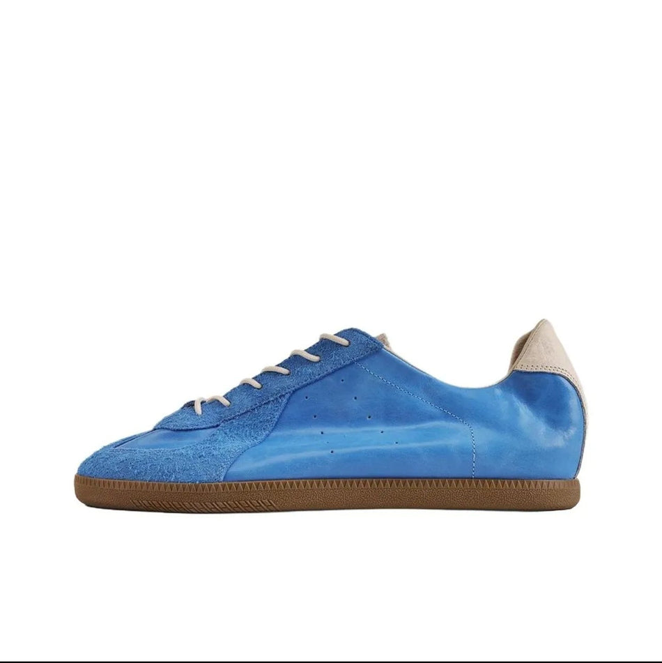 A blue suede sneaker with white laces and a brown gum sole, shown in a product listing screenshot on a white background.