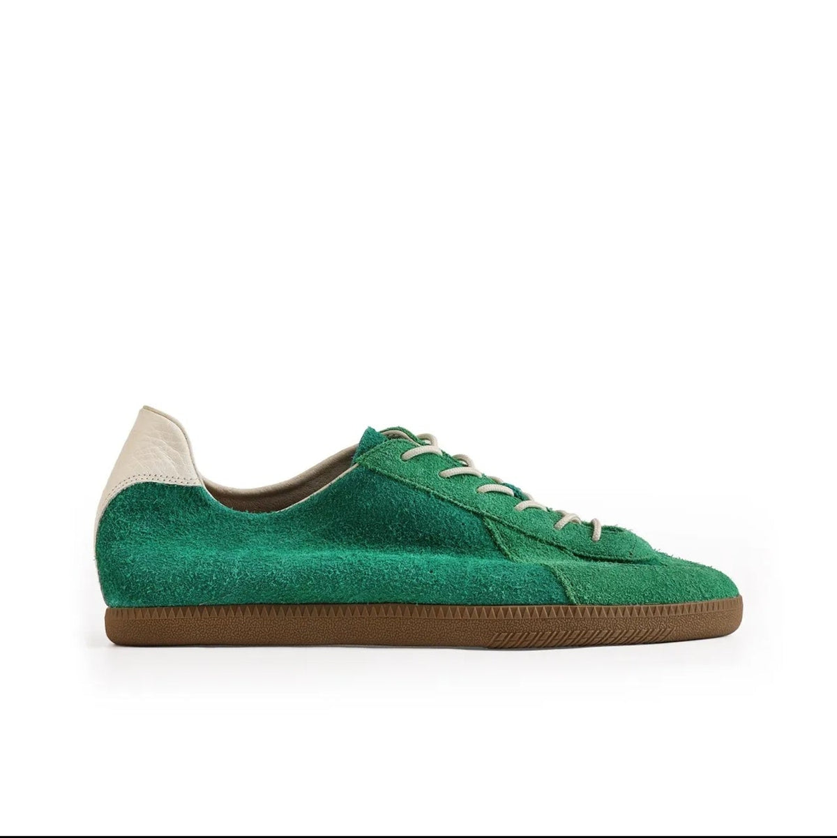 A green suede low-top sneaker with white laces and a brown gum sole, shown on a white background within a mobile app screenshot. Text below reads 'WILLOW CREEK 5217'.