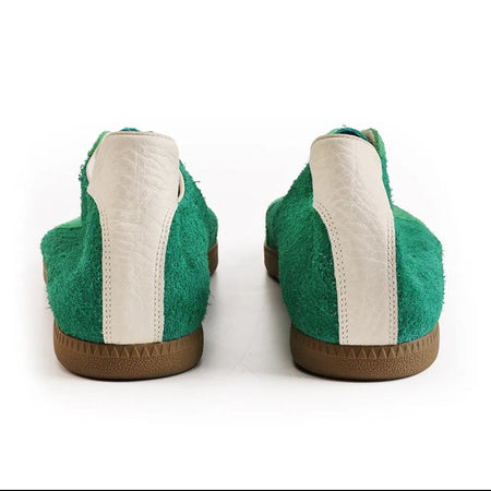 A pair of green slip-on shoes shown from the back on a white background, with a black phone app interface framing the photo.