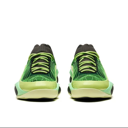 A pair of low-top sneakers shown from the back, featuring a bright green and lime-yellow patterned upper with black laces and a thick white midsole.
