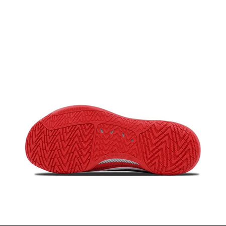 A red athletic shoe sole with a textured rubber tread pattern, shown from the bottom against a white background.