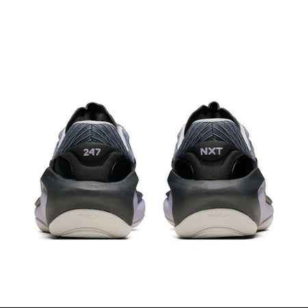 A pair of black and dark gray Nike sneakers shown from the back, with the '247' and 'NXT' logos visible on the heel, set against a plain white background.