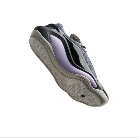 A single chunky sneaker shown on a plain white background, photographed from an angled side view. The shoe has a dark gray upper with black overlays and a light lavender-purple accent panel, paired with a thick gray and black sole.