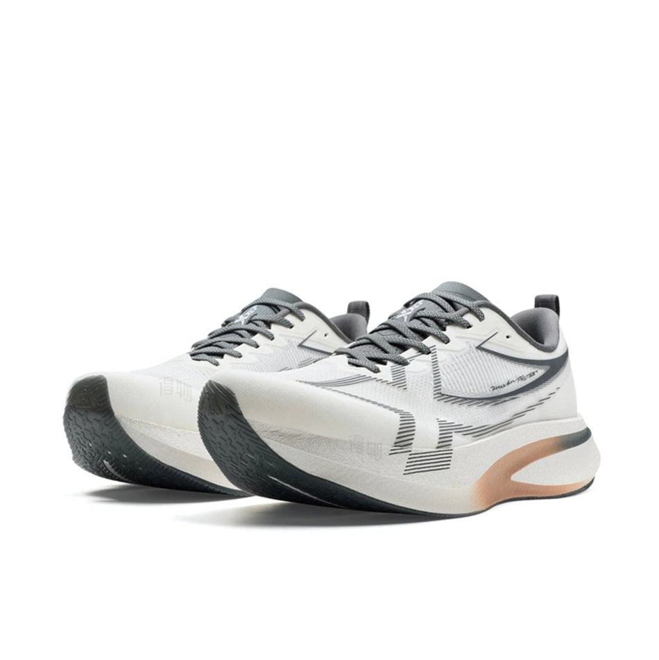 A pair of athletic sneakers in white, gray, and black with a small orange accent on the midsole, shown against a plain white background.